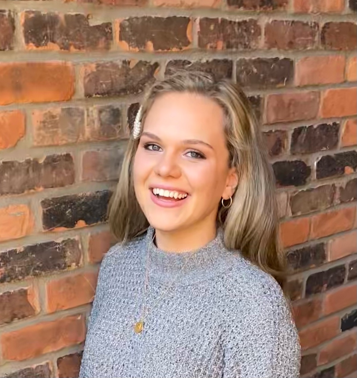 photo of a person in front of a brick wall