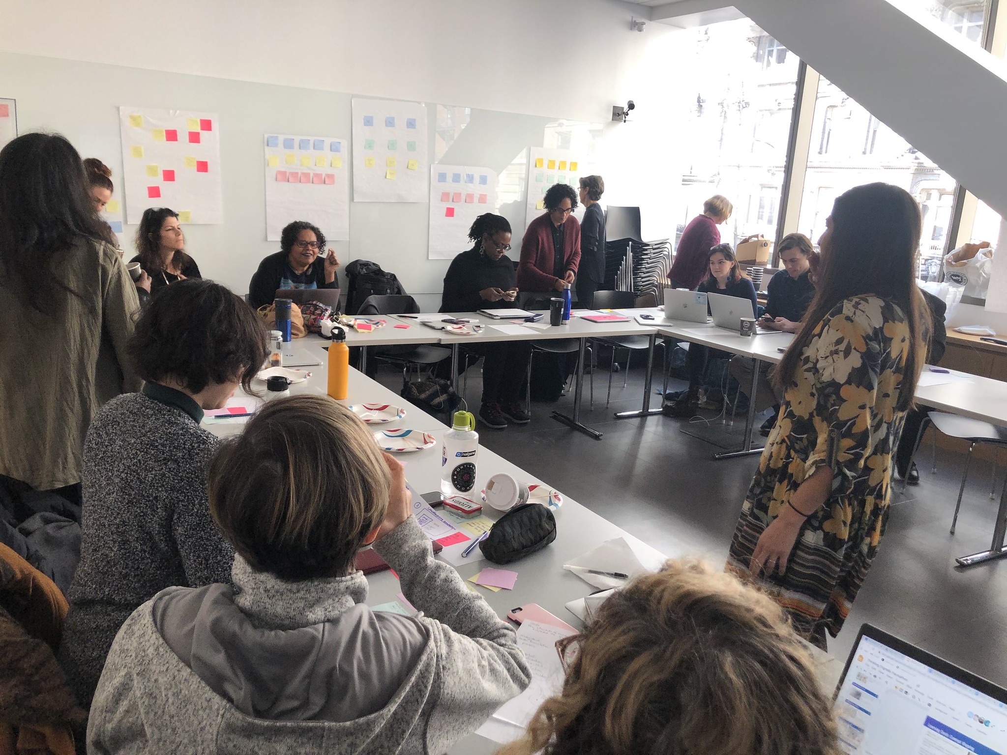 people gathered in a classroom with sticky notes and computers